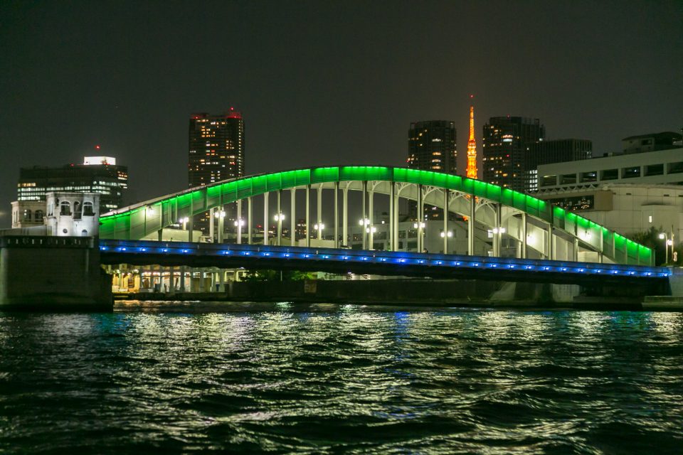 緑と青にライトアップされた勝鬨橋と東京タワーの夜景