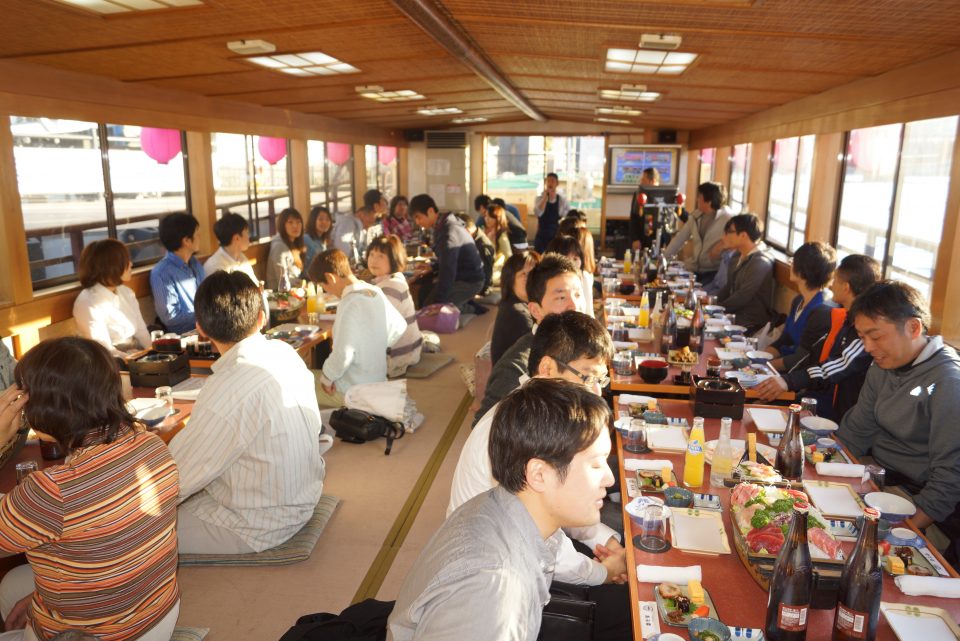 屋形船の船内で豪華な料理を楽しむお客様