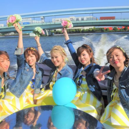 東京湾を疾走するアニー号のデッキでポーズを取る若い女性たち
