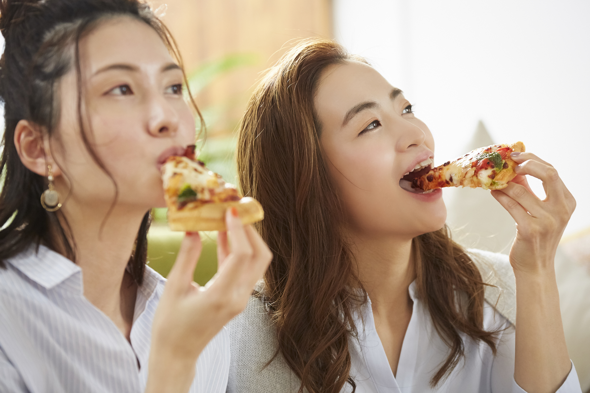 女性二人がピザを食べているシーン